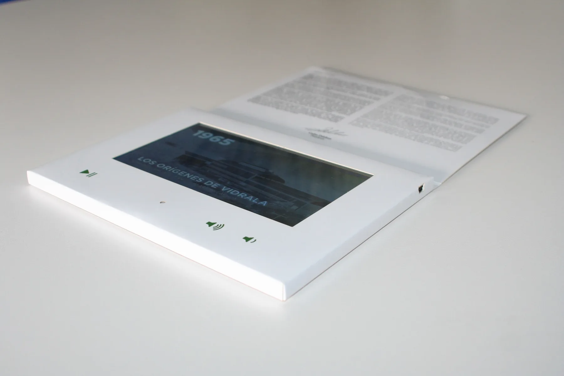 Carpeta blanca abierta con pantalla y texto en la tapa
