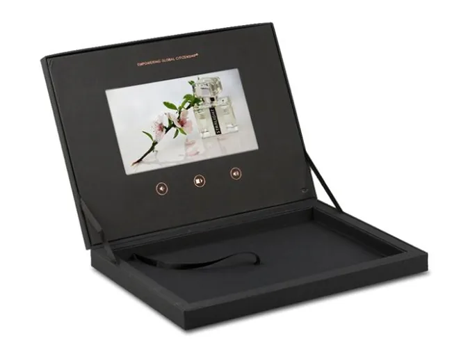 Caja negra plana con pantalla que muestra un frasco de perfume