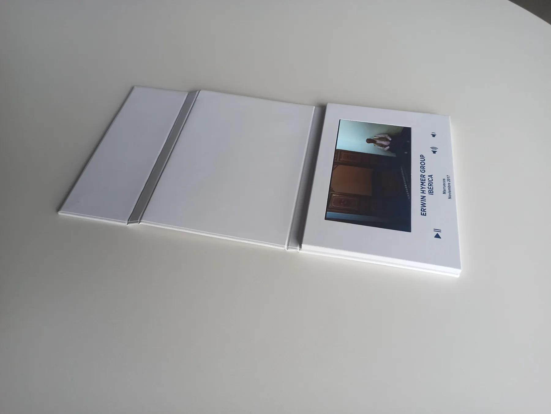 Tarjeta blanca desplegada en horizontal, con pantalla a la derecha